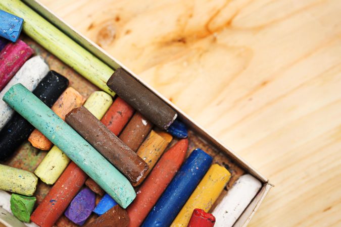 Box of colorful pastel crayons, space for text
