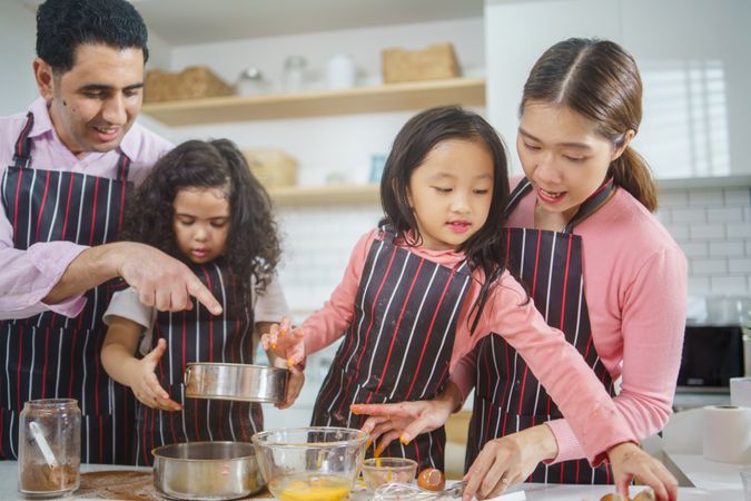 Young Asian family baking together in the kitchen