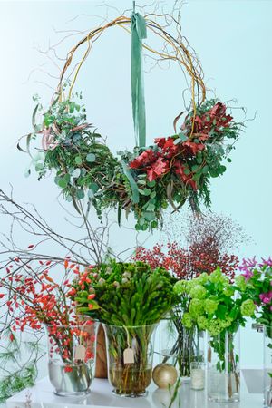Floral wreath and flower bunches in light room