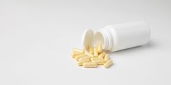 Mockup of a bottle of medicine capsules, or food supplement, lying down with copyspace