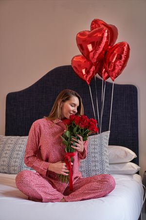 Happy female sniffing aromatic fresh bouquet of red roses