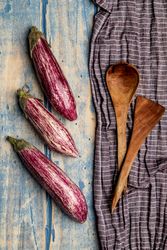 Ripe eggplants on shabby tabletop
