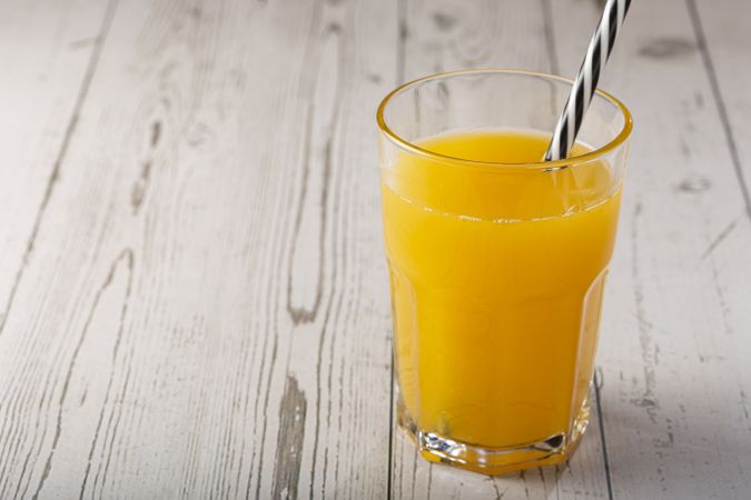 Glass with orange juice on the table.