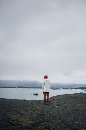 Man standing on coast on overcast day, vertical