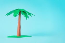 Palm tree made of paper on blue background