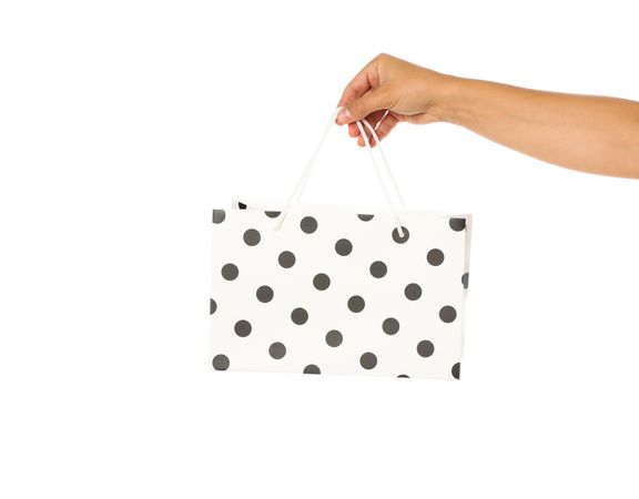 Female hand hold color paper bag isolated on blank background