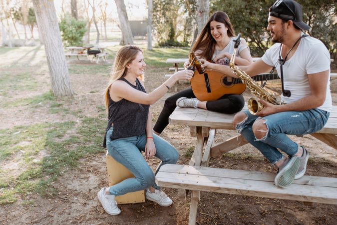 Young musicians drinking beer in park
