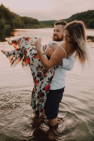 Loving couple standing ankle deep in water on beach