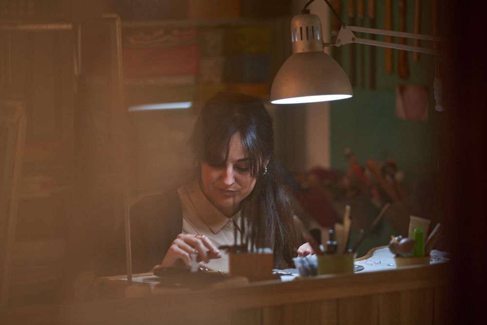 Focused female jeweler checking new created accessories