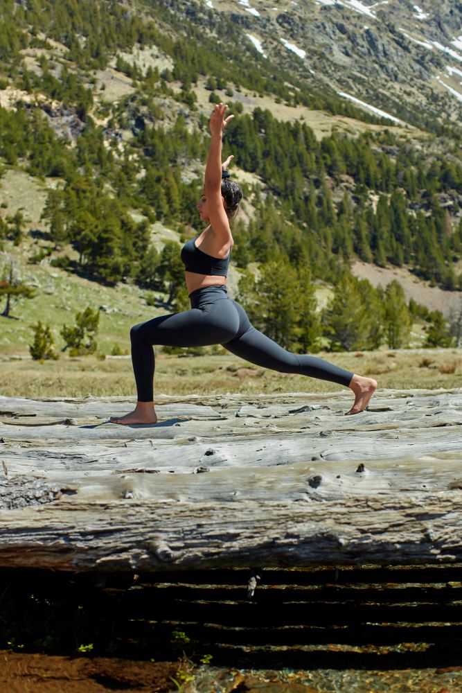 Side view of young woman doing yoga in a valley outside