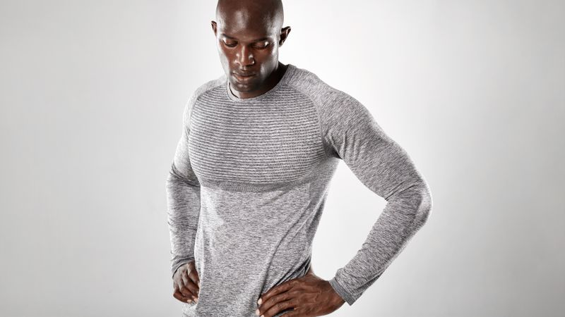 Muscular and strong African male model against grey background