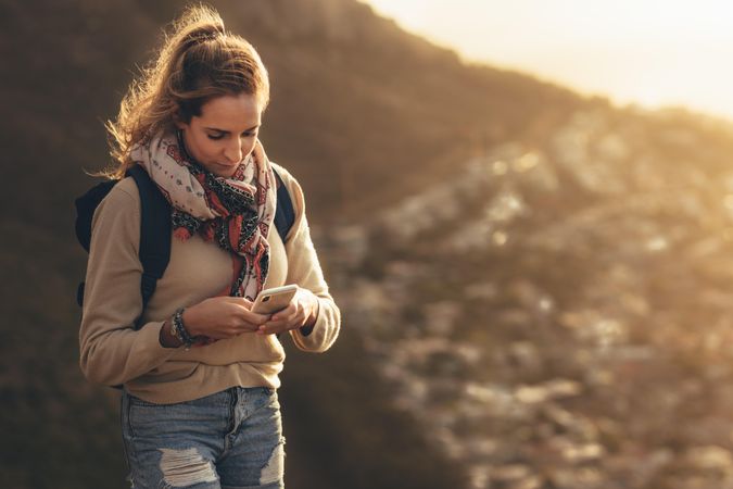 Young woman on hiking trip using smart phone