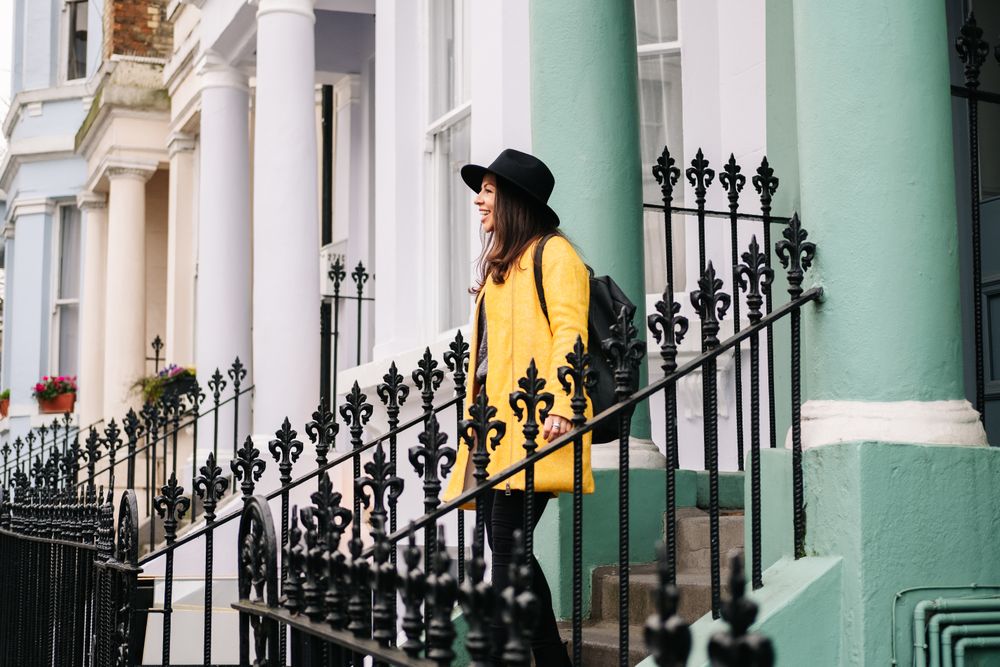 Cheerful woman standing in stairs in typical london buildings