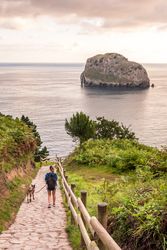 Female hiker with dog walking on seaside