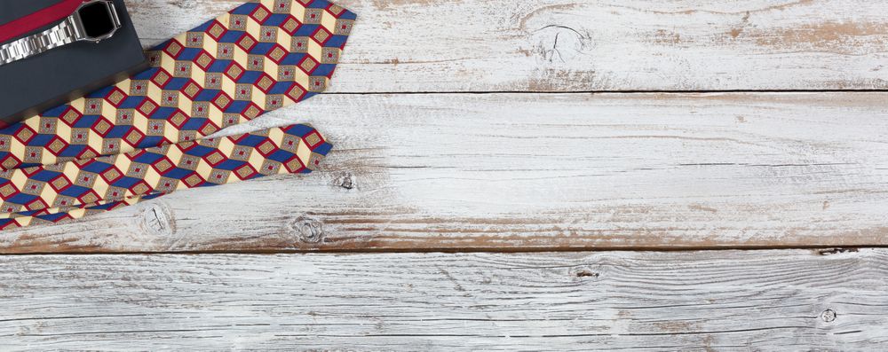 Gift box with watch and dress tie on rustic wood with plenty of copy space
