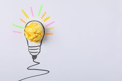 Drawn light bulb and paper ball on light background. Good idea concept