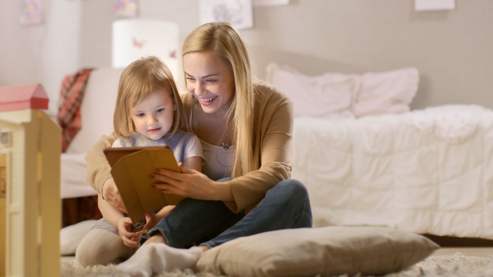 Mother and Her Daughter Have Good Time Reading Children's Books on a Tablet Computer.