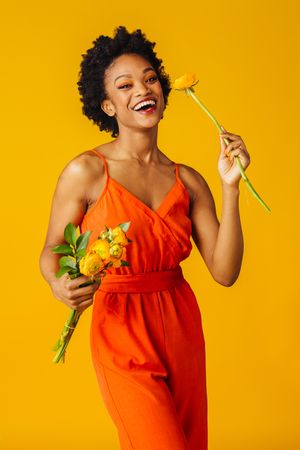 Beautiful Black woman holding ranunculus flowers
