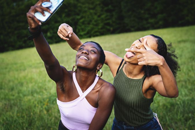 Good female friends taking selfies in the park making faces