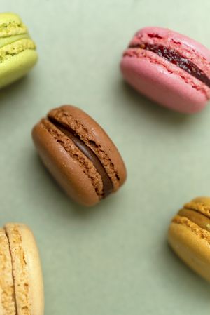 Above view of pastel macaroons on a green table