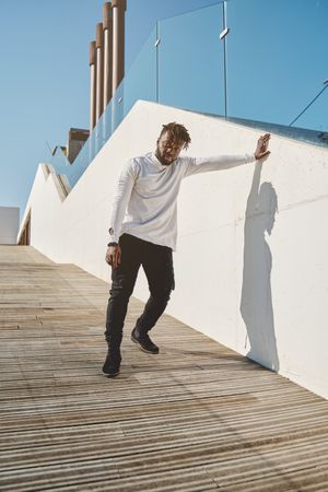 Black man standing on wooden ramp in city