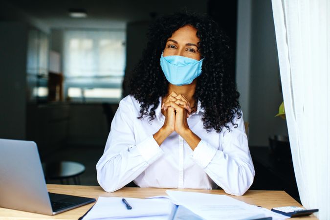 Content woman wearing a facemask working on documents