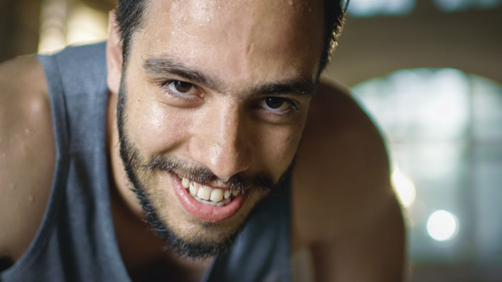 Exhausted Bend Muscular Man Looks into Camera and Rests After Intensive Workout.