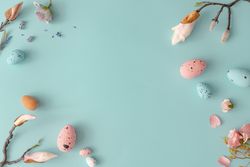 Easter composition made with flowers and eggs on bright blue background