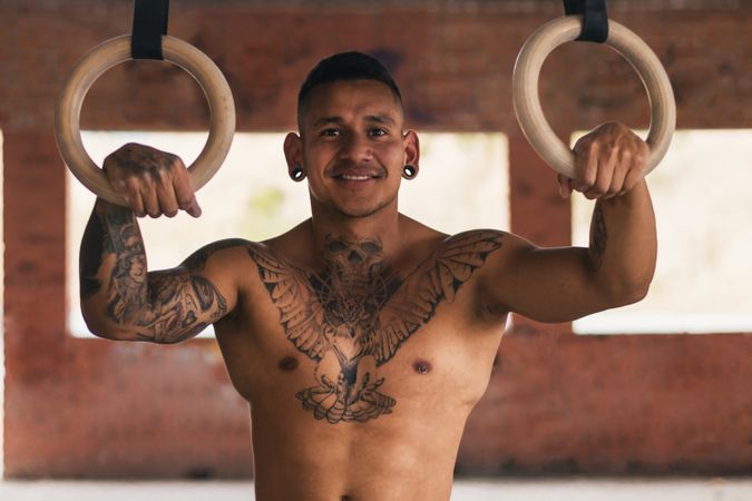 smiling male athlete with gymnastic rings