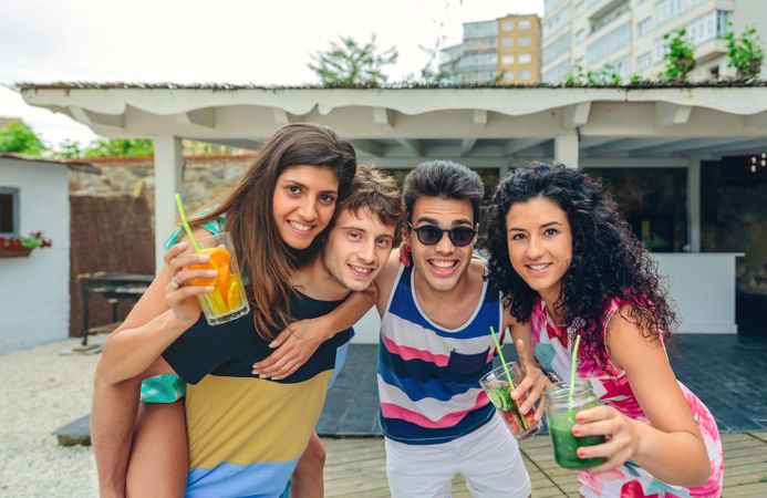 Young adults enjoying fruity cocktails outside