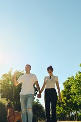 Couple walking and playing with their dog