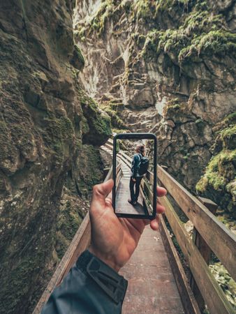 Tourist taking photo while walking on footpath