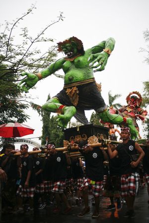 Green statue being carried by men during Hindu prayer ceremony