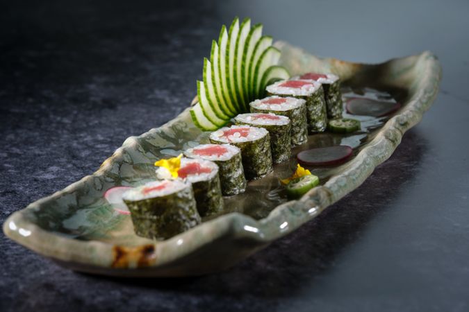 Delicious tuna sushi rolls served with fresh cucumber slices arranged on marble tray