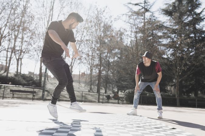 Guy looking at man dancing break dance in park