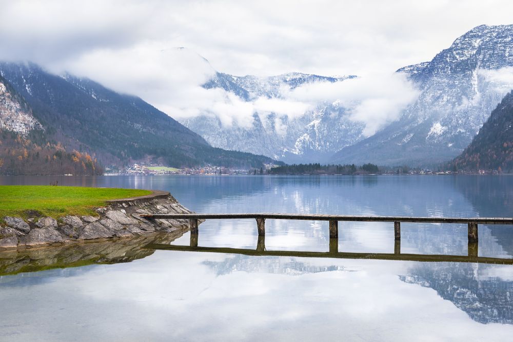 Wooden deck over mountain lake with alps behind