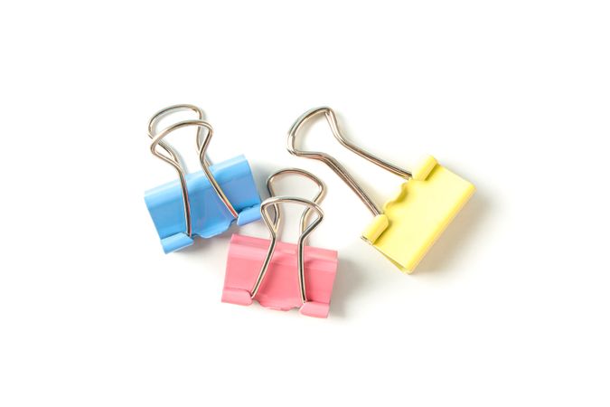 Color paper clips isolated on studio background