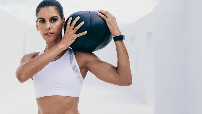 Close up of a fitness woman holding a medicine ball