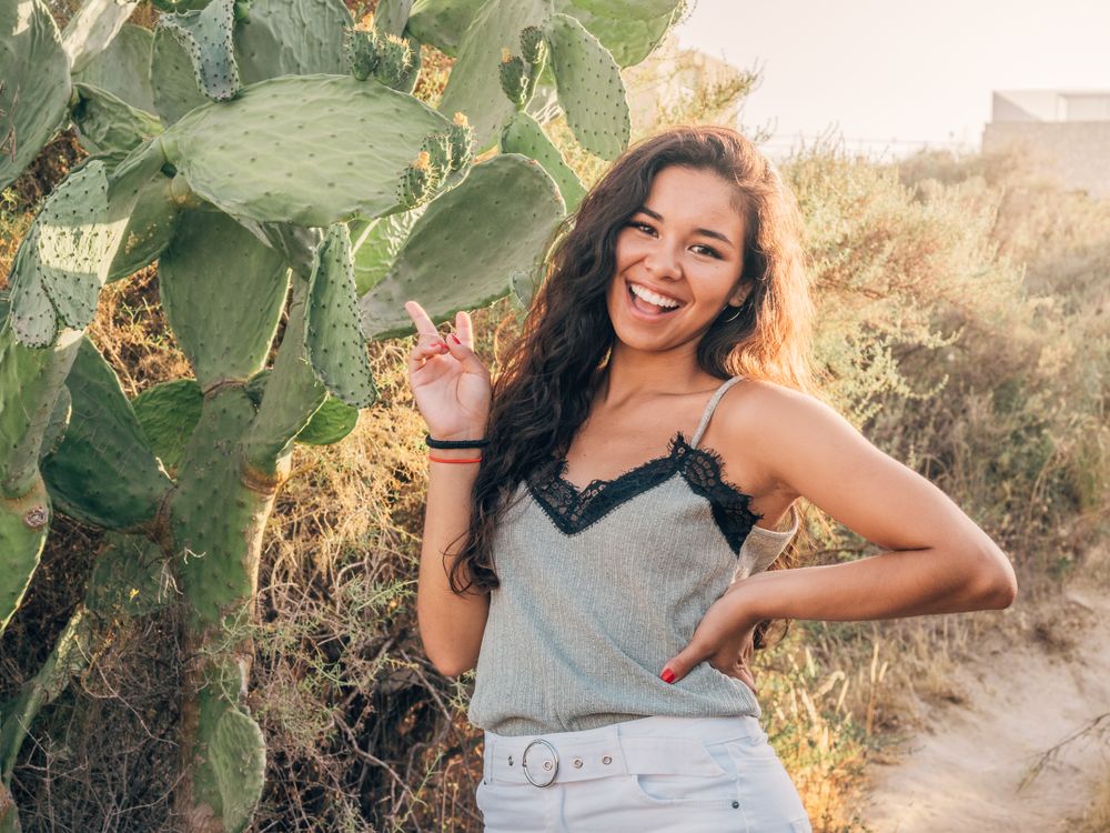 Playful trendy young woman in deserted countryside