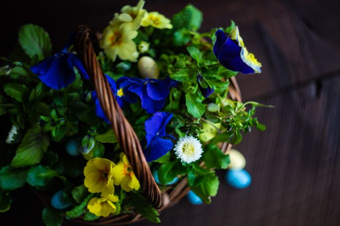 Basket of flowers with pastel decorative eggs
