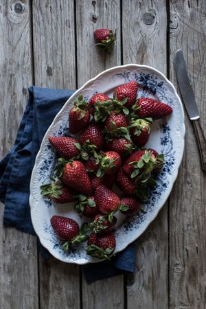 Plate with strawberries near napkin and knife