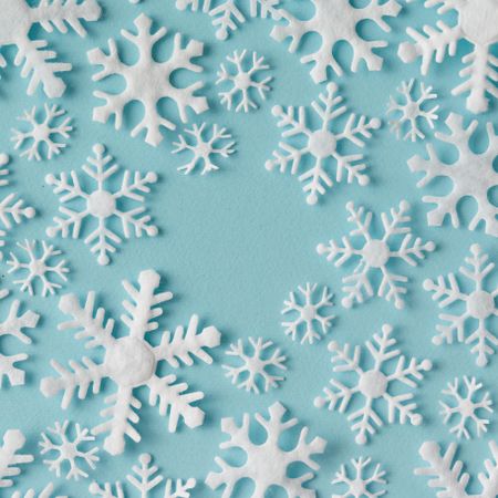 Winter pattern made of different sized snowflakes on blue background
