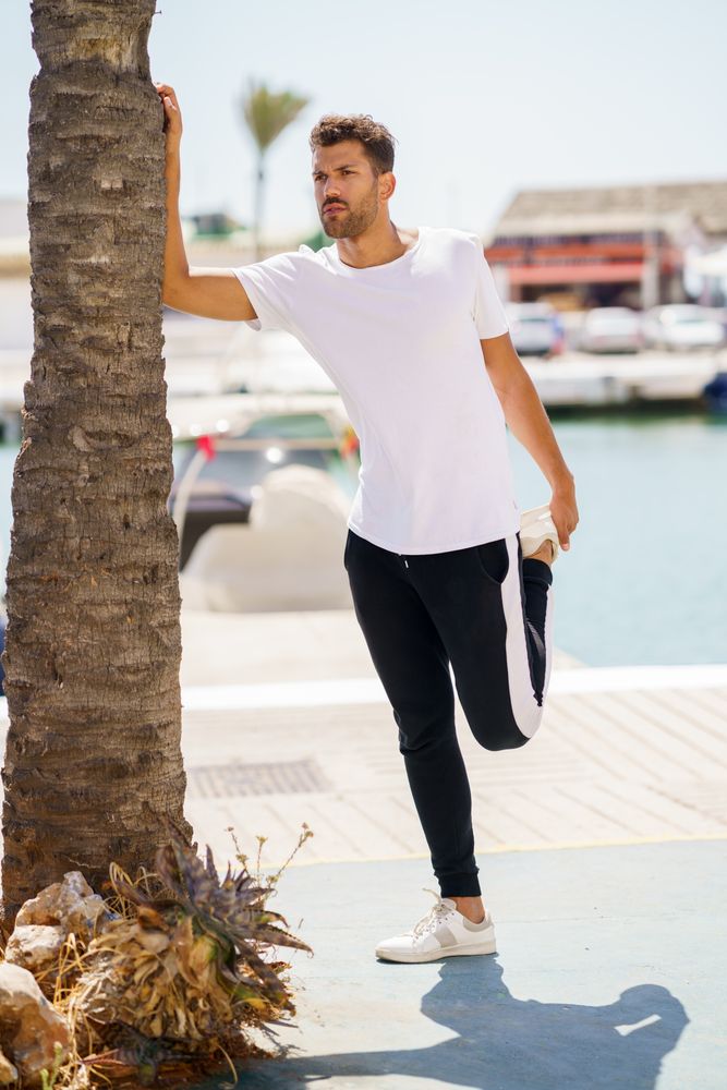 Man balancing next to palm tree as he warms up