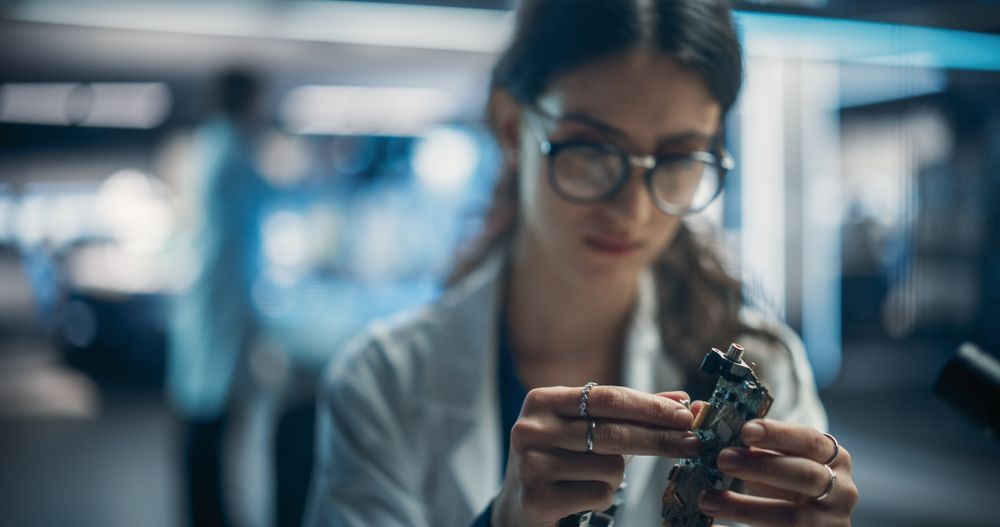 Focused Professional Female Engineer Working on Electronic Circuit Boards.