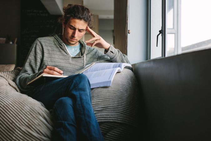 Student sitting at home looking tense studying seriously