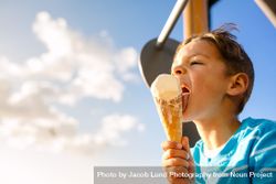 Close up of a boy licking an ice cream on a bright sunny day 0yXgwG