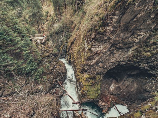 Traveller admiring picturesque view of mountain stream