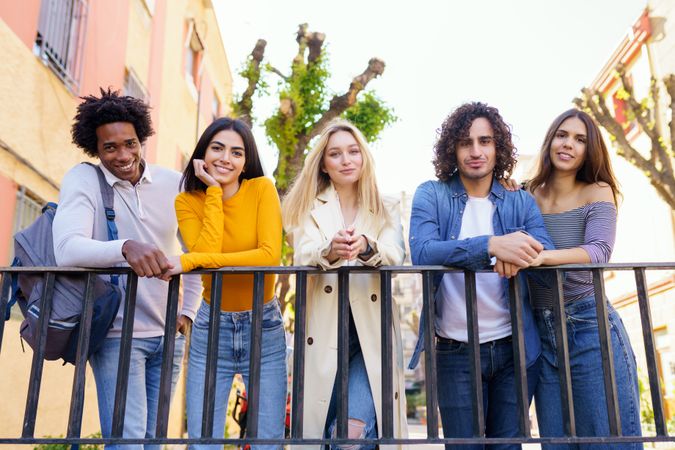 Portrait of male and female friends standing in a row and smiling