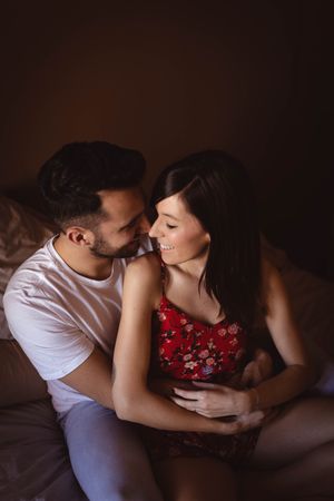 Happy couple sitting on bed