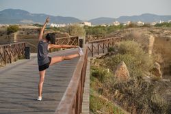 Unrecognizable sportswoman stretching while preparing for traini